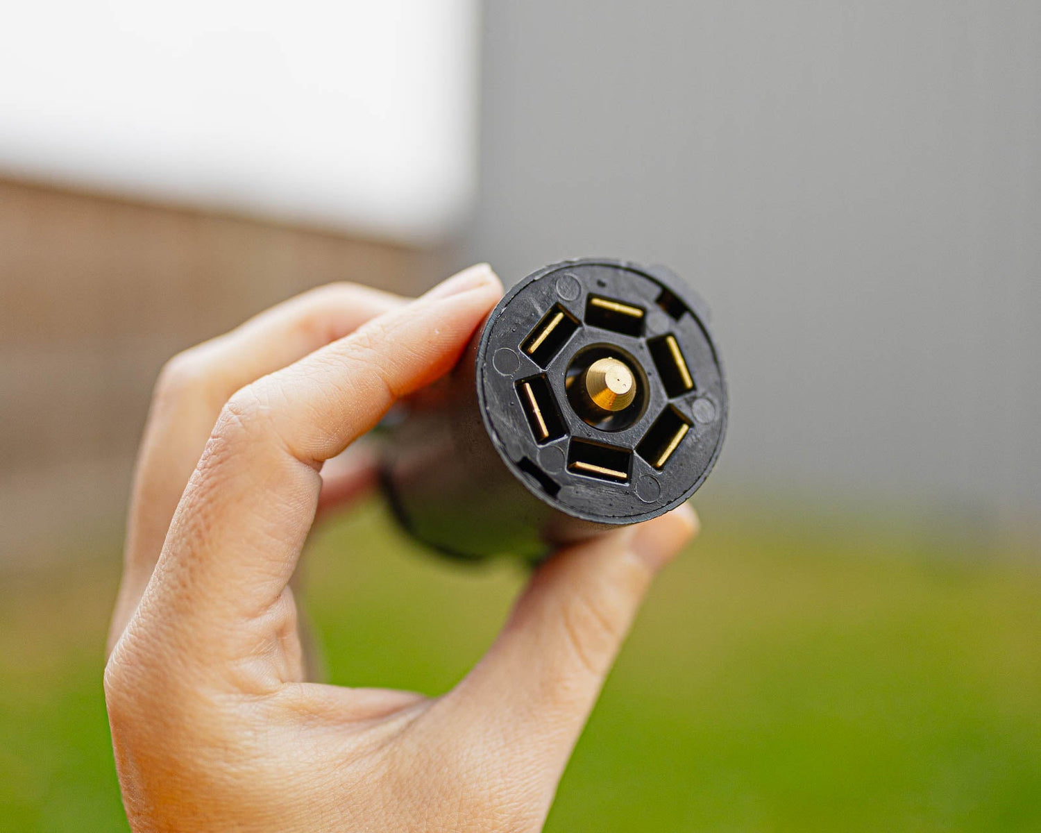 7 pin trailer connector is held up to look at the wiring points.