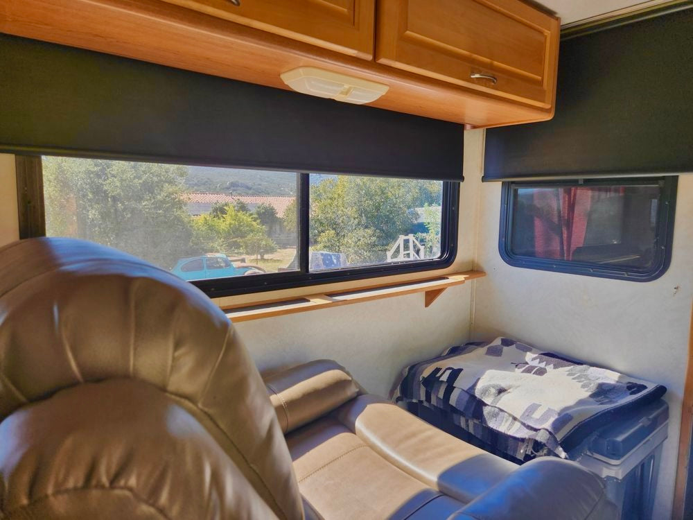 Interior shot of an RV with new roller shades installed without valances.